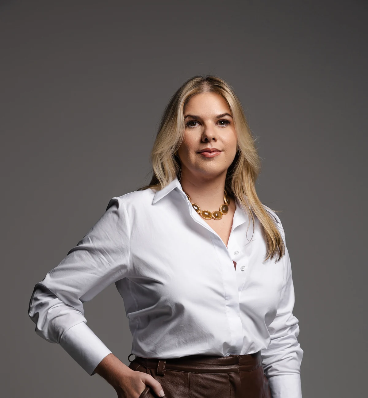 Dra. Camila Feola, dermatologista em Limeira, em retrato com camisa branca.