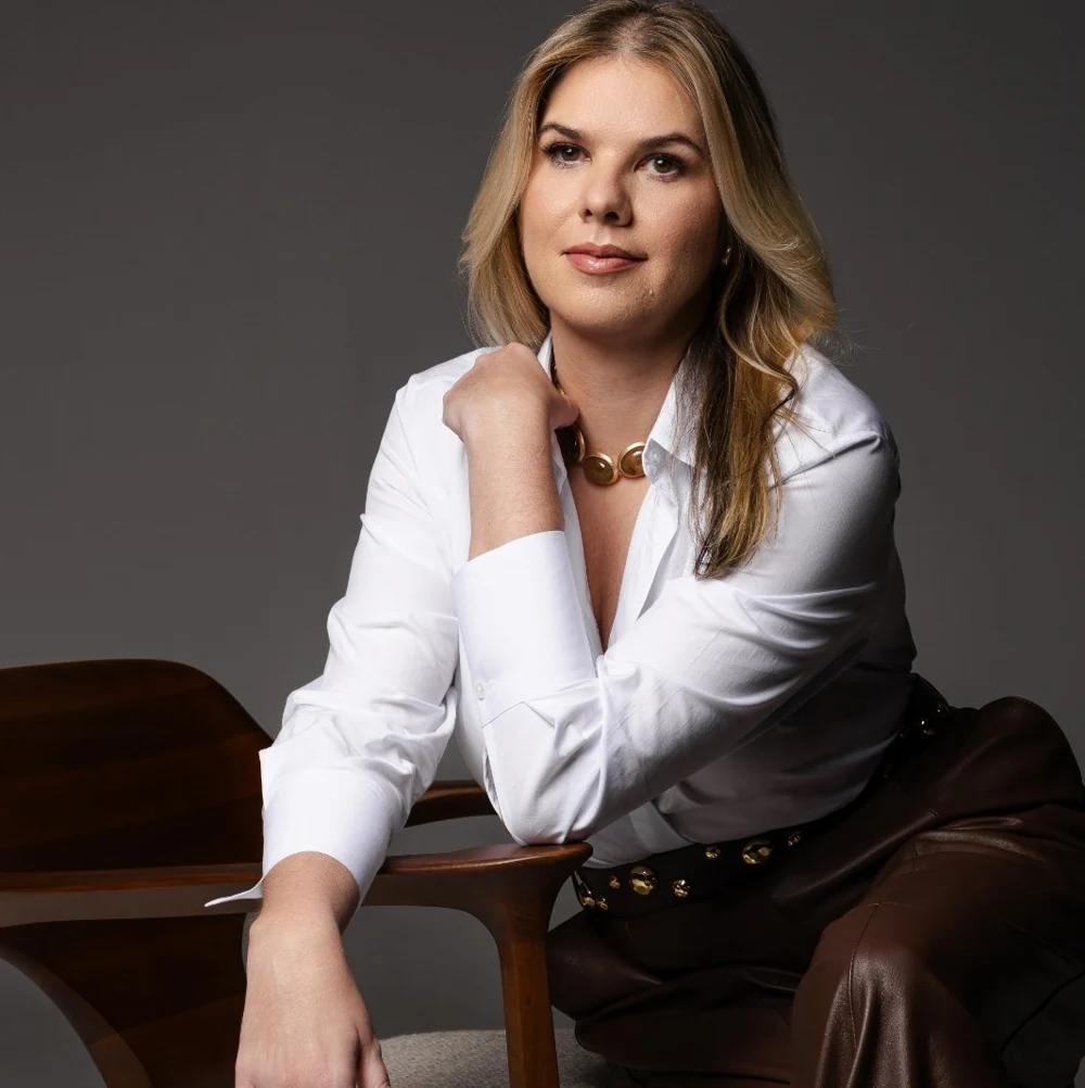 Dra. Camila Feola sentada, em retrato oficial do consultório.